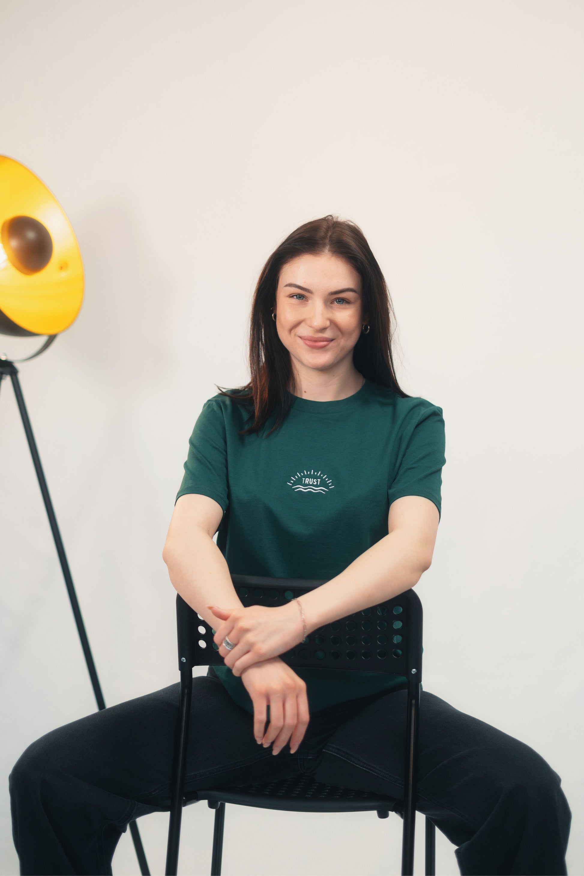 Model Oberkörperaufnahme sitzend, Produkt T-Shirt, Motiv Trust, Farbe Glazed Green