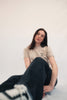 Model Ganzkörperaufnahme sitzend, Produkt T-Shirt, Motiv Walk by Faith, Farbe Desert Dust