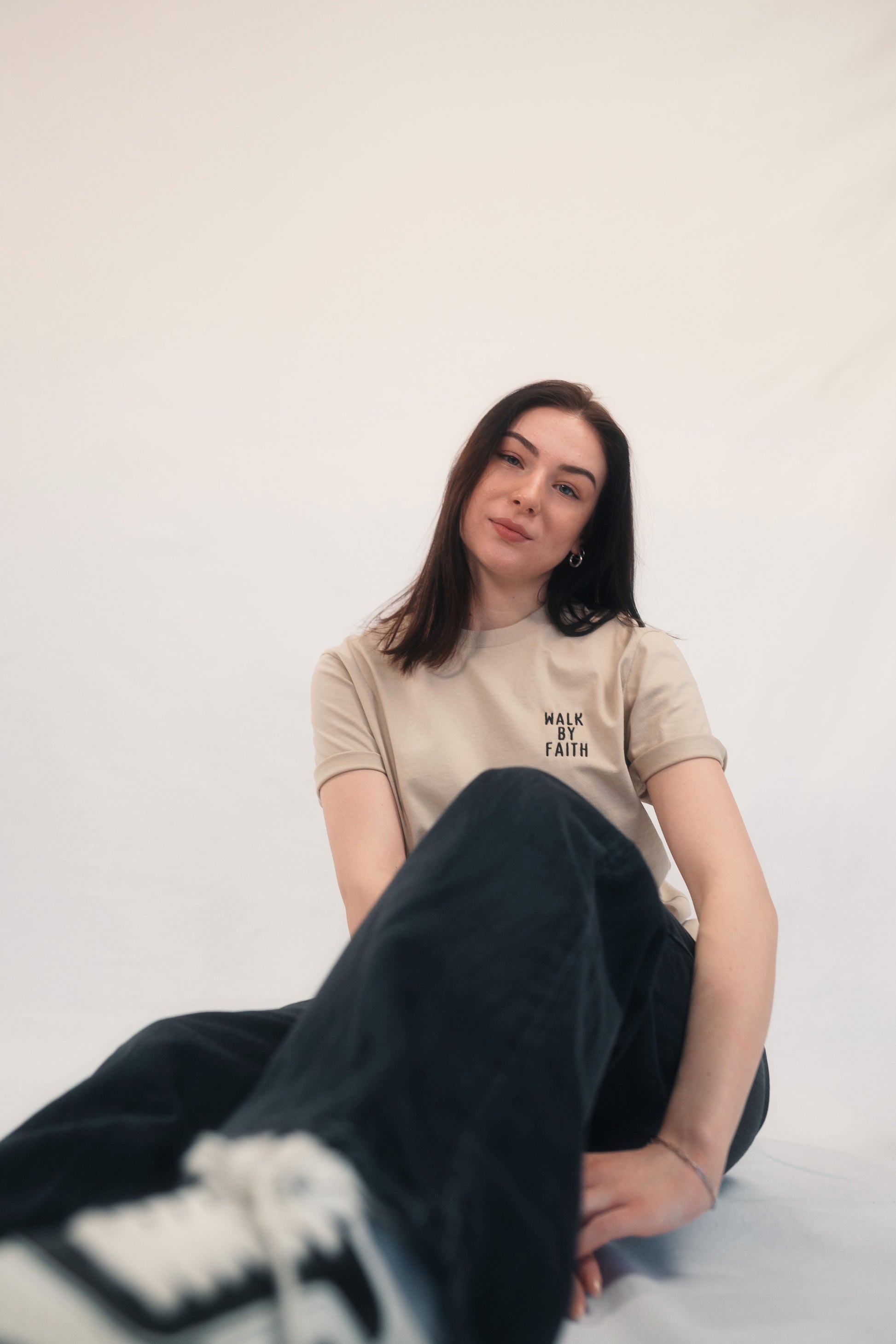 Model Ganzkörperaufnahme sitzend, Produkt T-Shirt, Motiv Walk by Faith, Farbe Desert Dust