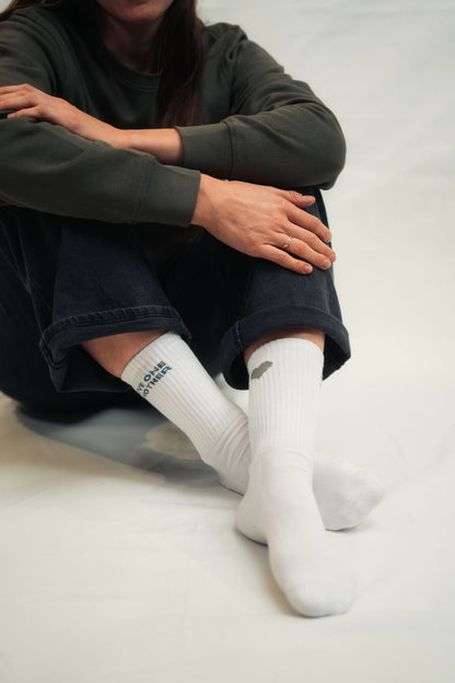 Model präsentiert Mission One More Socken mit christlicher Bedeutung "Love One Another" nachhaltiges Design