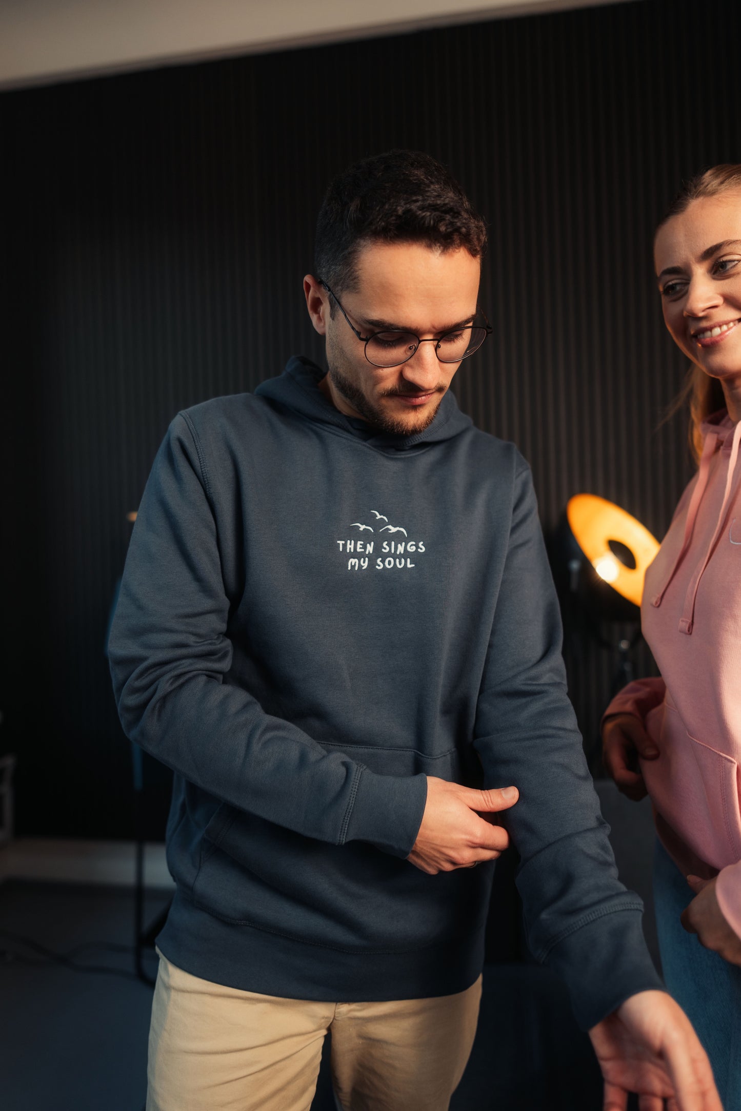 Model im Wohnzimmer trägt Mission One More Glaubens-Hoodie nachhaltige Fair Fashion