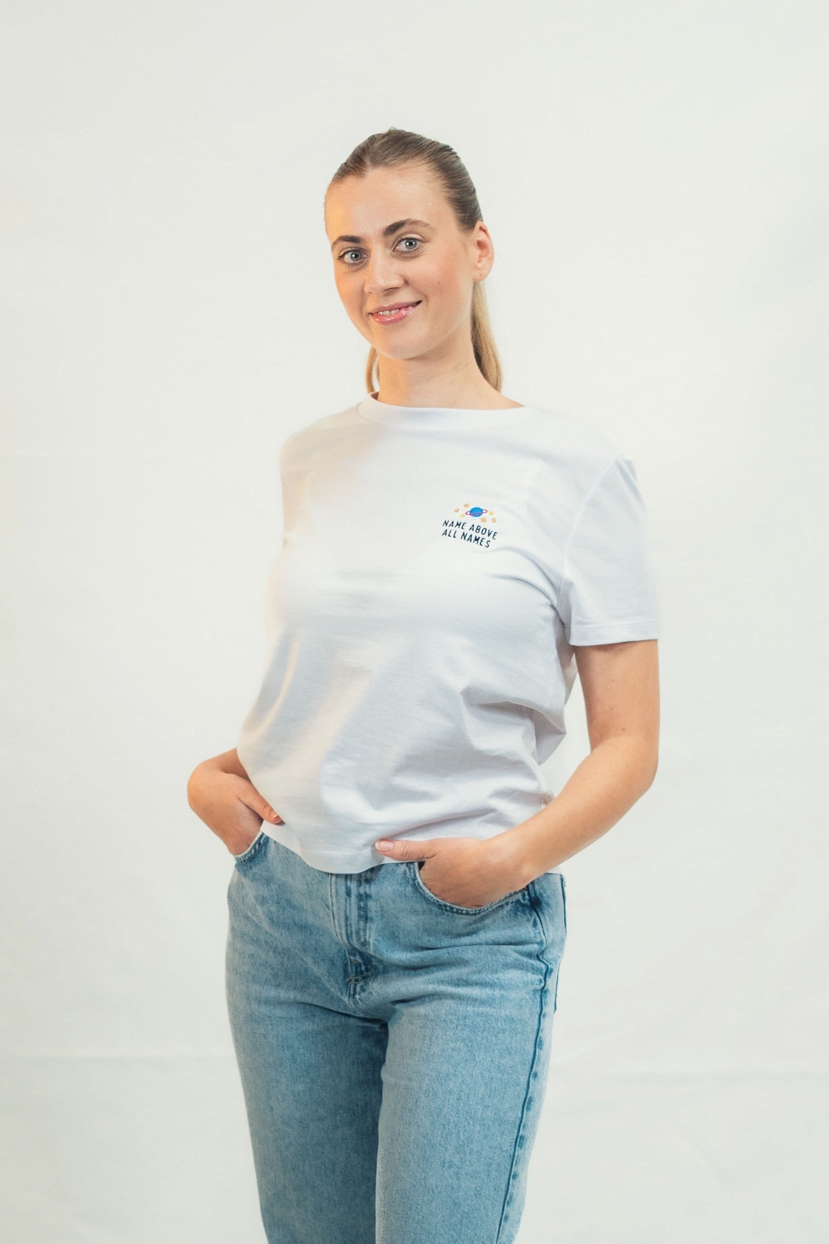 Model trägt Mission One More weißes Bio-T-Shirt mit zeitloser christlicher Gestaltung "Name above all Names"