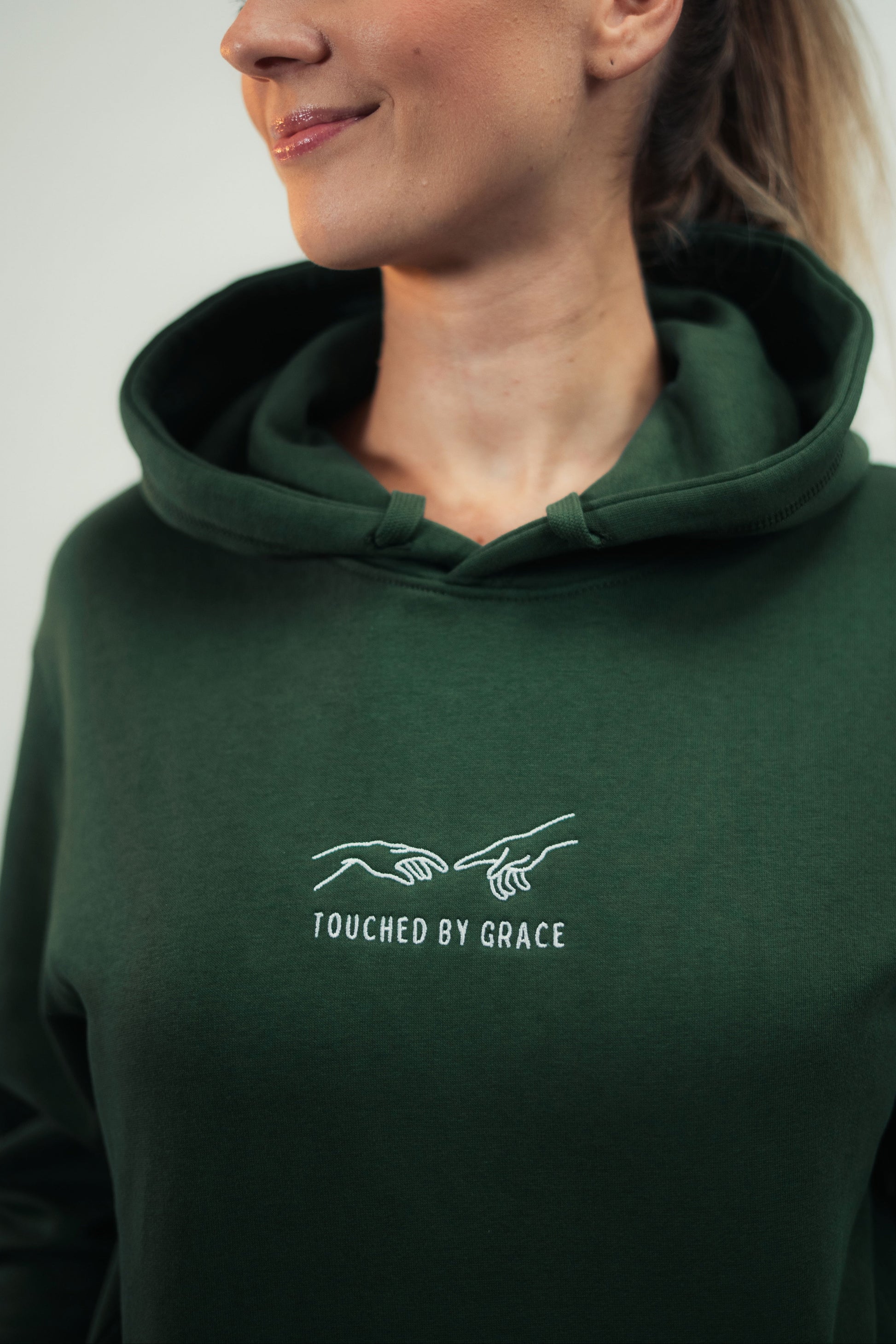 Model zeigt Mission One More Fair Fashion Hoodie christliches Stickdesign und Material Fokus